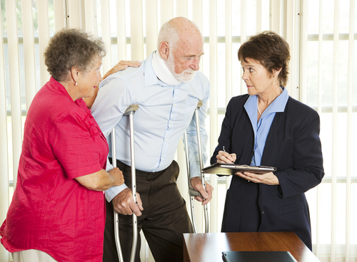 Attorney speaking with elderly client on crutched