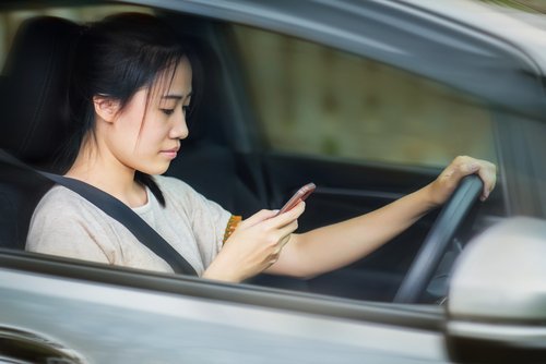 Woman texting while behind the wheel. Since this is intentional behavior, it qualifies as gross negligence if it causes an accident. 