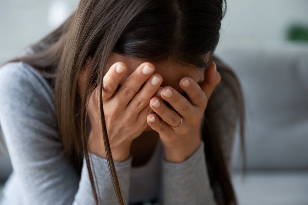 A woman slumped over in utter sadness, possibly due to the death of a close relative.